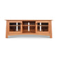 A Maple Corner Woodworks Cherry Moon 68" TV Console with a curved front, featuring three open shelves and three drawers with white handles, isolated on a white background.
