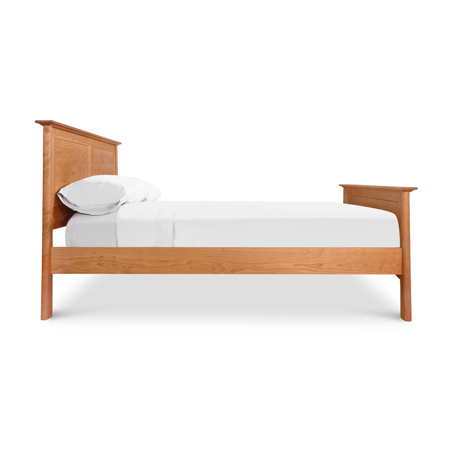 Maple Corner Woodworks Cherry Moon Panel Bed in cherry wood, viewed from the side with a simple white mattress and pillow.