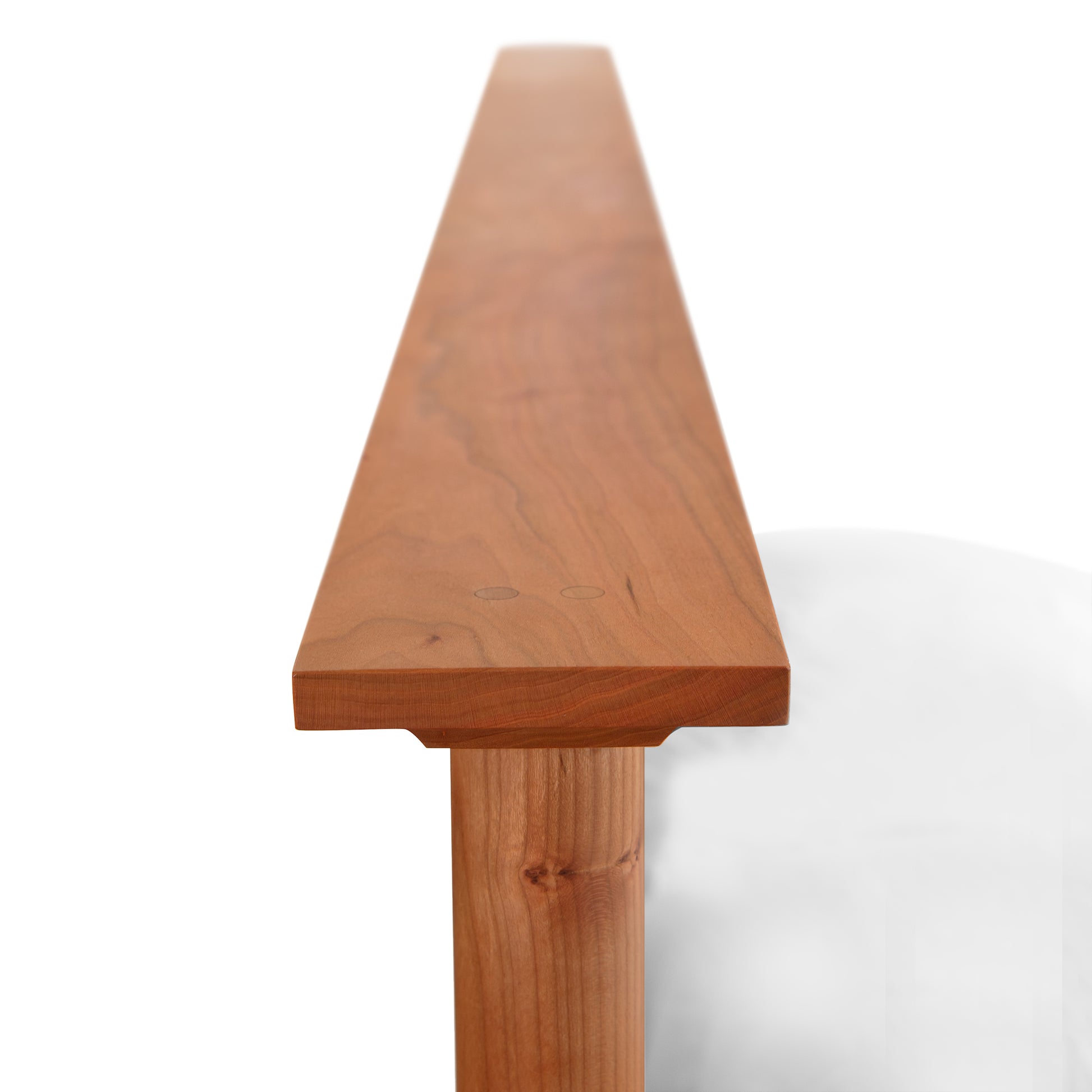 Detail view of the Cherry Moon Panel Bed by Maple Corner Woodworks, showcasing the handcrafted cherry wood corner and panel design.