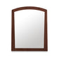 An arched wooden frame surrounding a Maple Corner Woodworks Cherry Moon Vertical Mirror.
