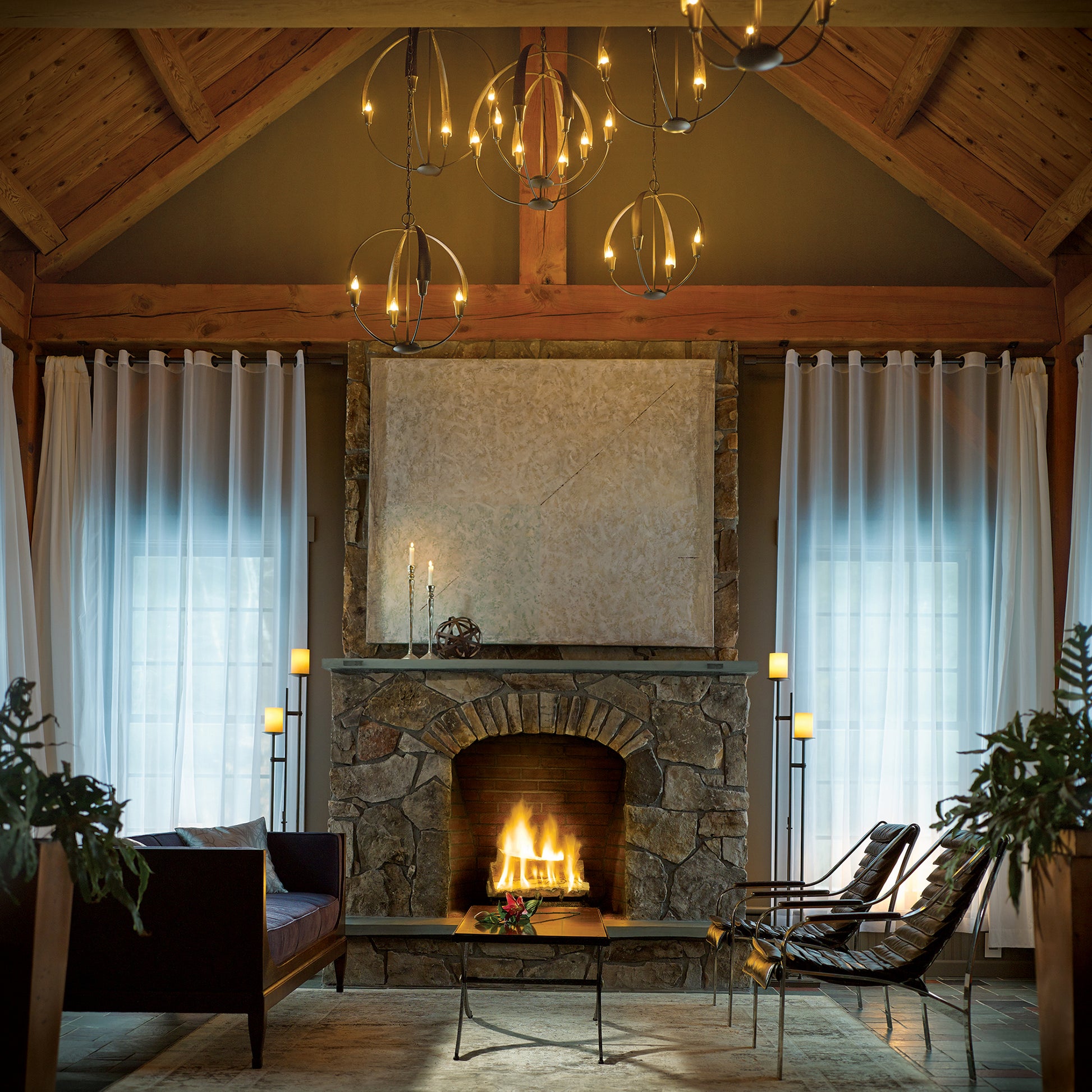 Hand-crafted Hubbardton Forge Cirque Chandelier illuminating eco-friendly rug seating in a cozy living room.