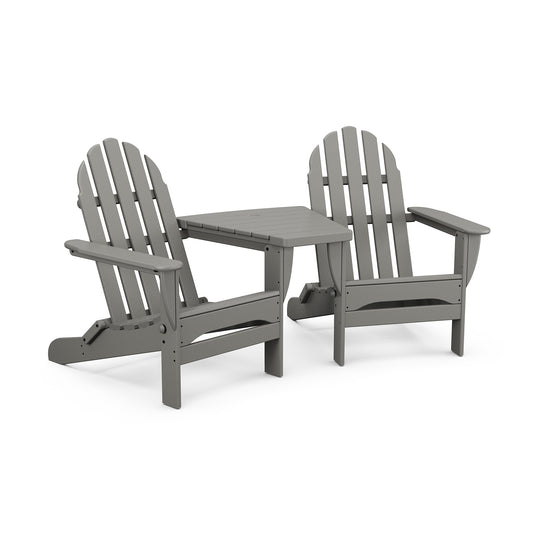 Two gray folding POLYWOOD Classic Folding Adirondack chairs connected by a small table, displayed against a white background. The design is simple and functional, ideal for outdoor settings.
