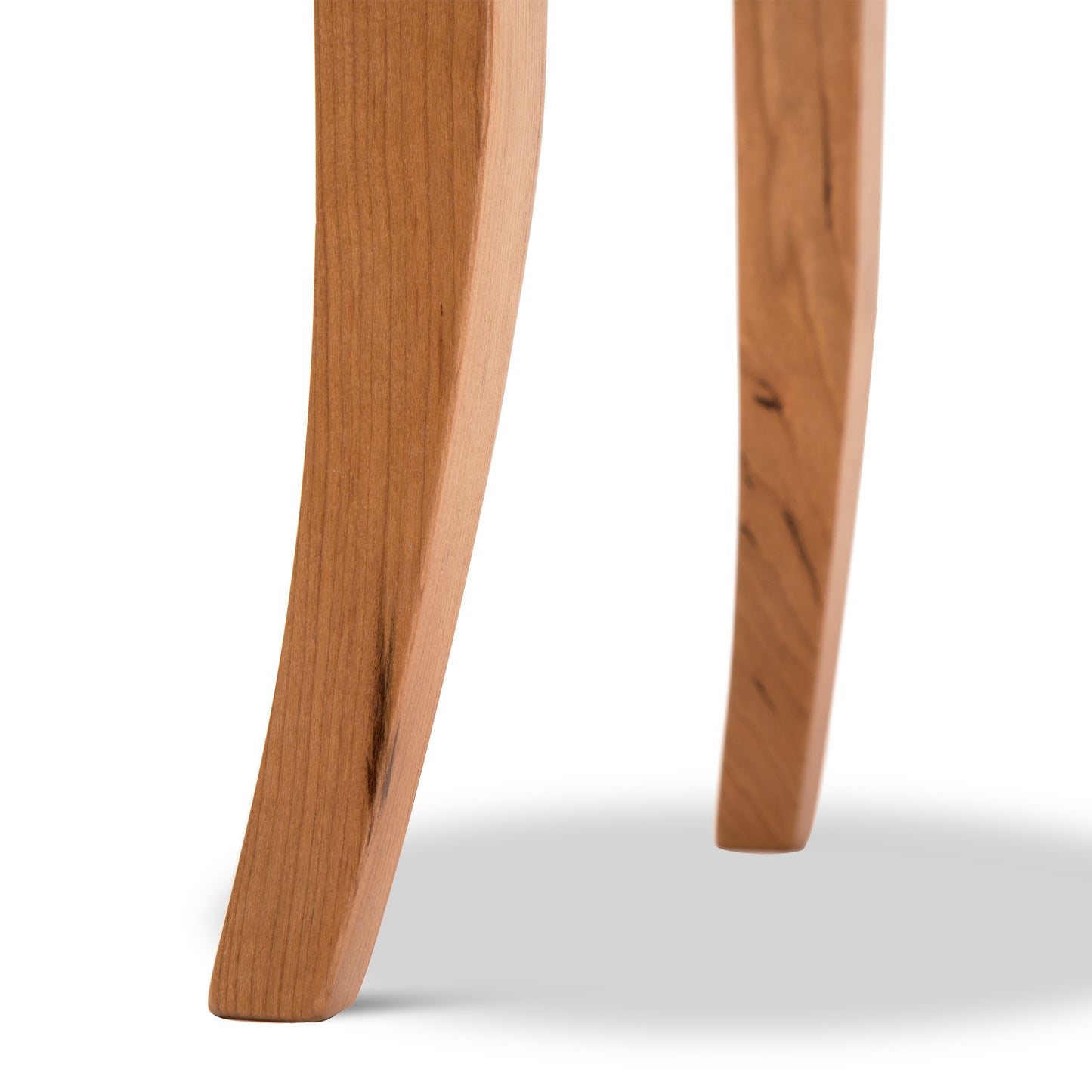 Detail of the solid wood flare legs on the Lyndon Furniture Classic Shaker Round End Table, highlighting craftsmanship and natural wood grain.