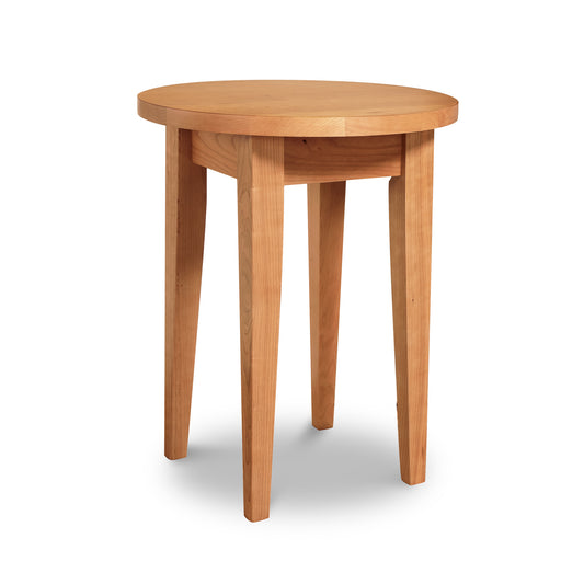 A simple Lyndon Furniture Classic Shaker Round End Table with four legs isolated on a white background.