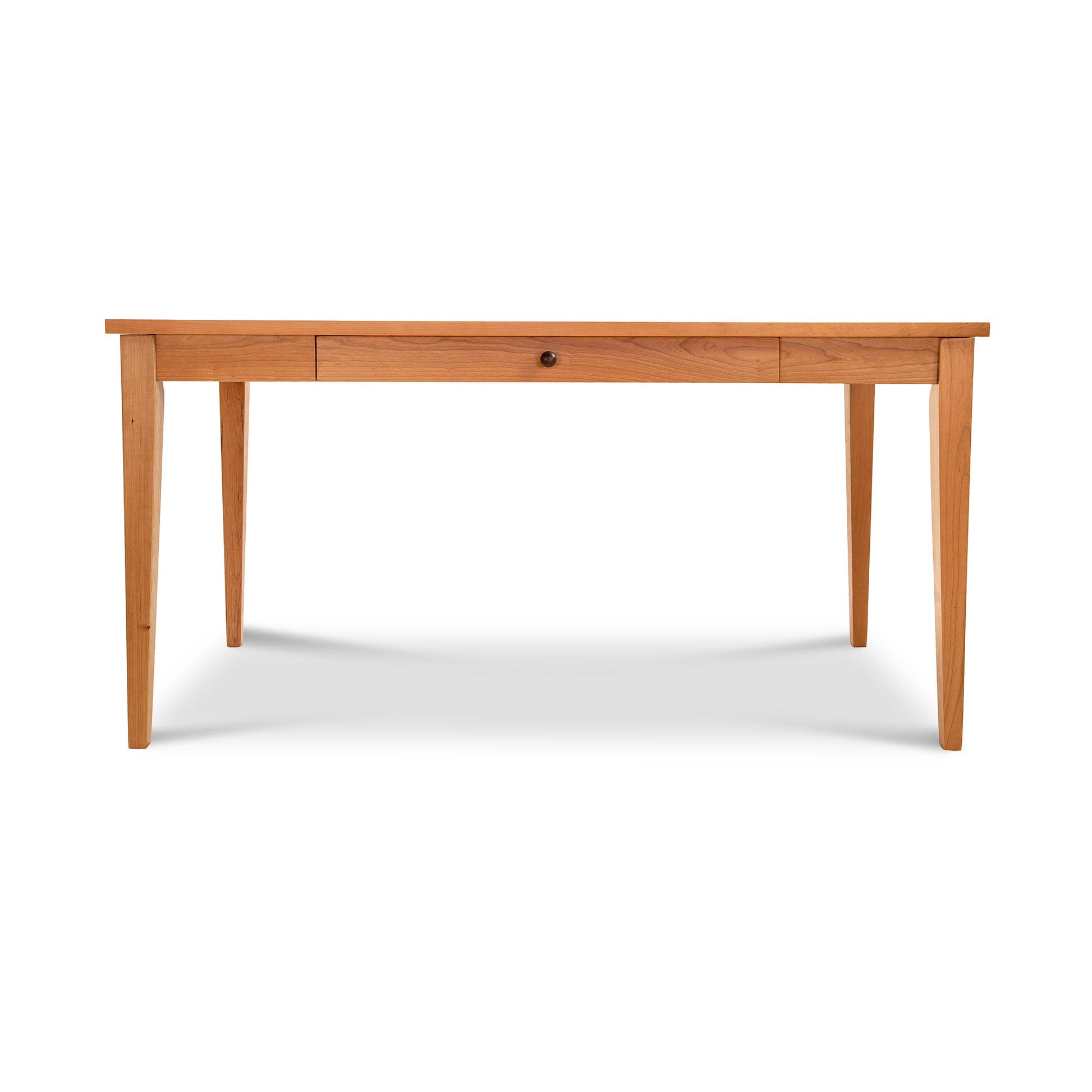 A simple eco-friendly Lyndon Furniture Classic Shaker Writing Desk with a smooth surface and slender legs, featuring two shallow drawers, each with a round black knob, set against a plain white background.