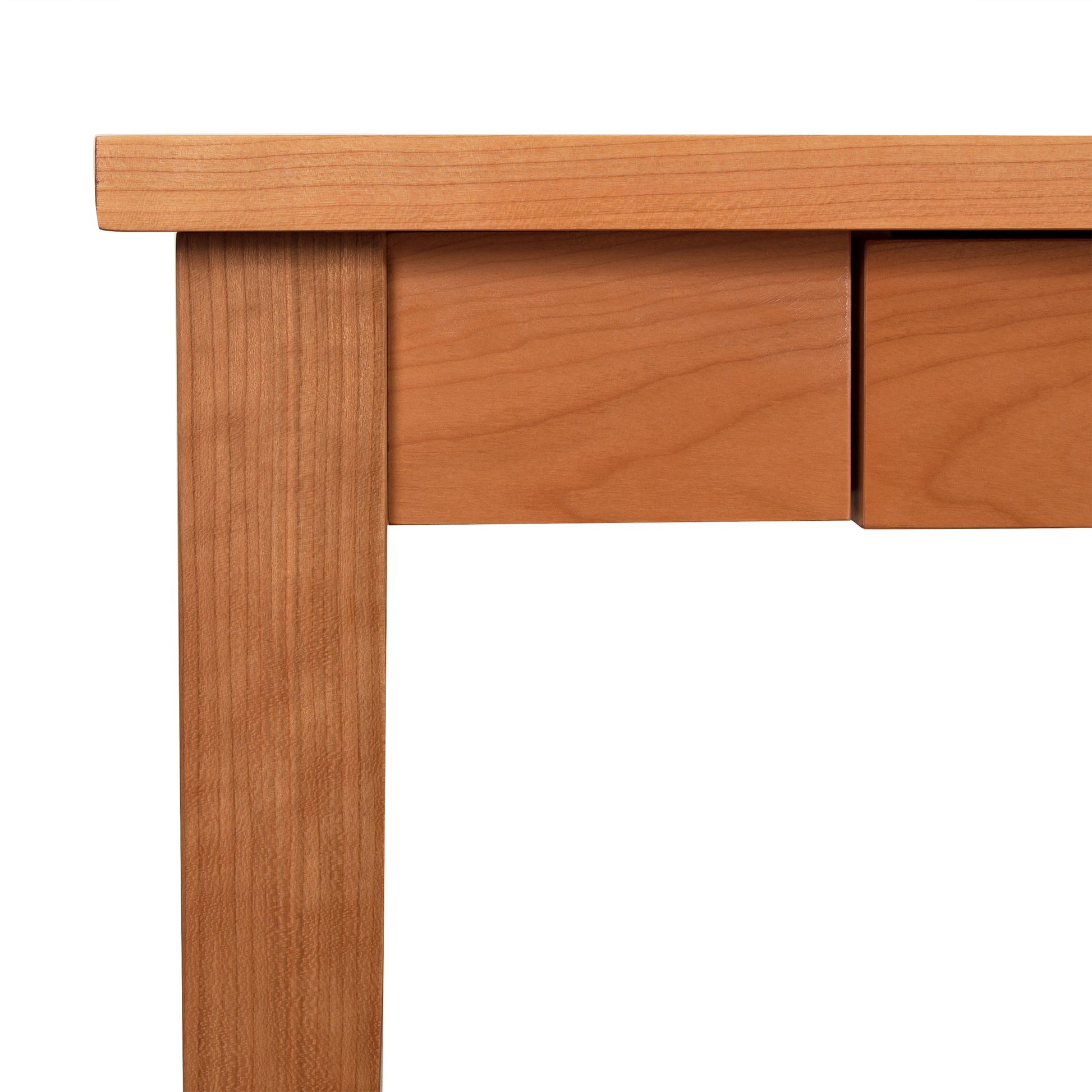 Close-up of a Lyndon Furniture Classic Shaker Writing Desk corner showing clean, straight edges and seamless joints, highlighting the smooth texture and natural grain of the wood.