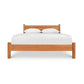 A handcrafted Lyndon Furniture Classic Wood Bed made of sustainably harvested solid woods, featuring white sheets.