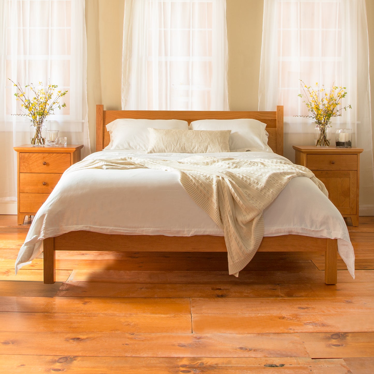 Lyndon Furniture's Classic Wood Bed with white bedding and beige throw.