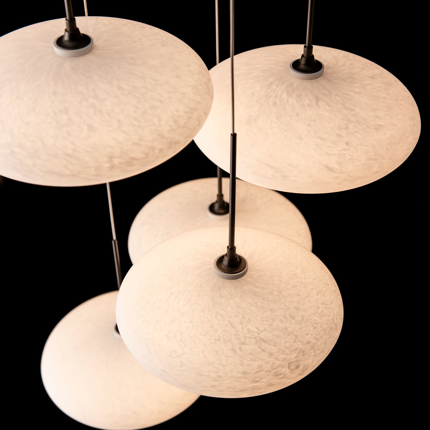 Hubbardton Forge Clouds 5-Light Pendant with five round, textured glass lights on black rods, highlighting modern American craftsmanship.