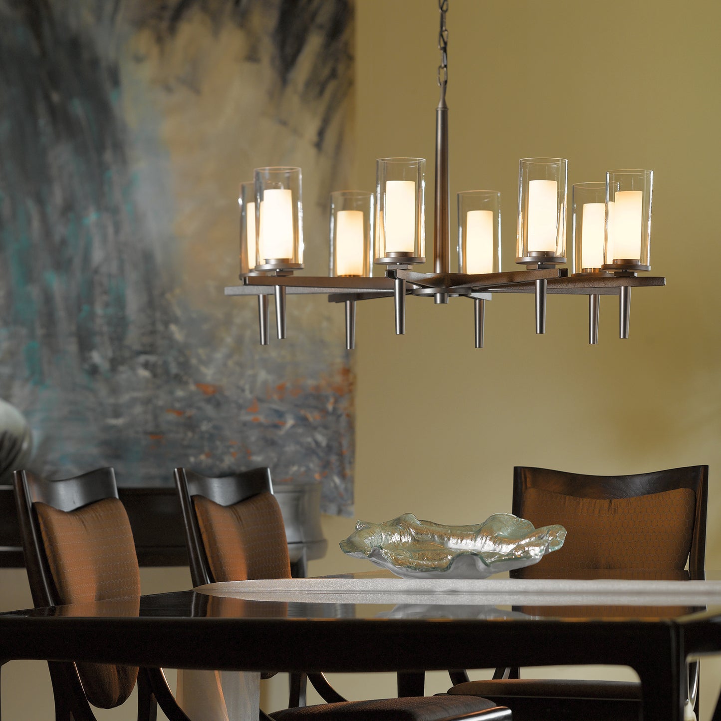 A Constellation 8-Arm Chandelier from Hubbardton Forge hanging over a dining room table.