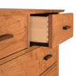 Contemporary Craftsman 7-Drawer Chest by Vermont Furniture Designs with one drawer partially open, revealing dovetail joints and an eco-friendly oil finish.
