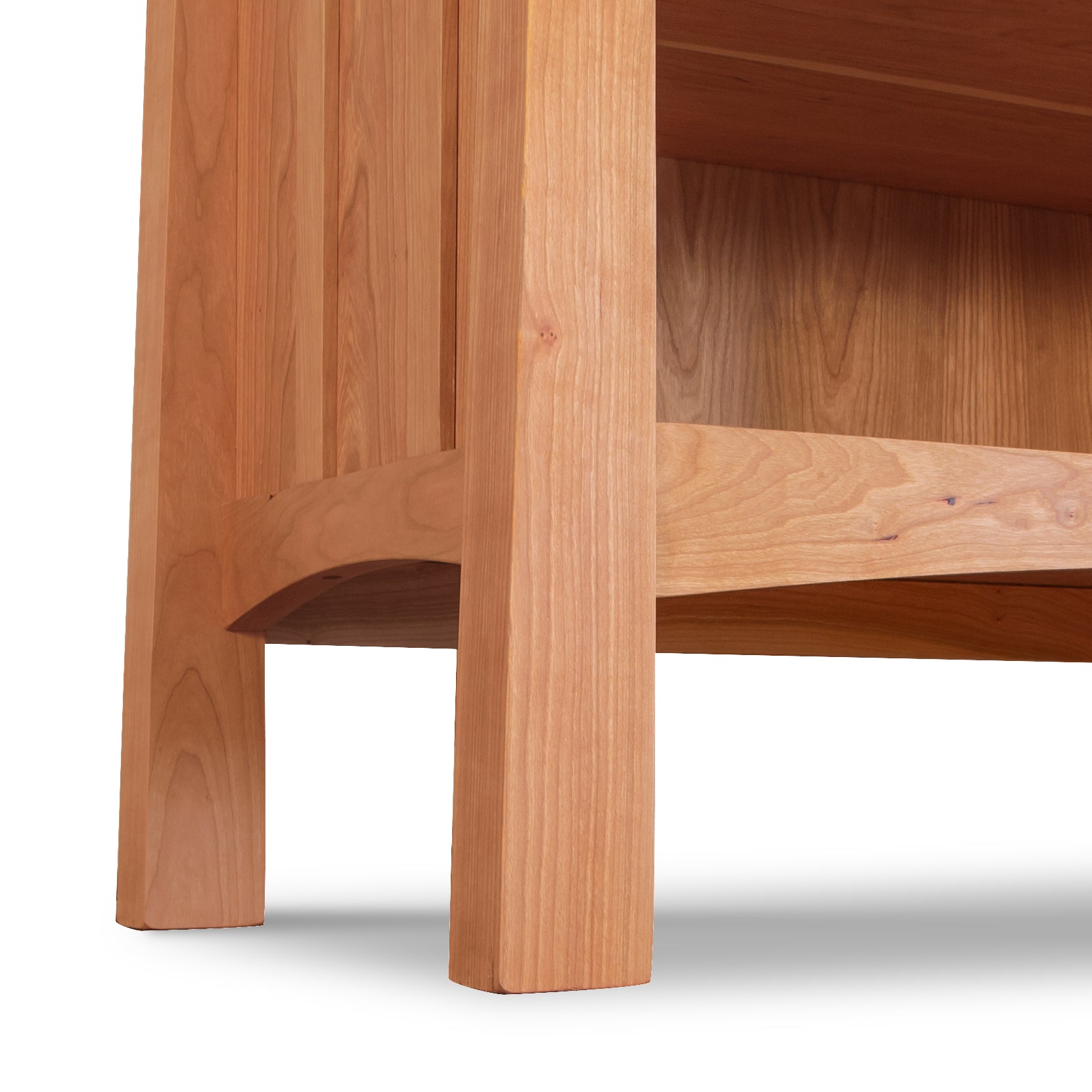Detail of the lower corner and tapered legs of the Vermont Furniture Designs Contemporary Craftsman Custom Bookcase, highlighting expert wood craftsmanship.