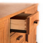 A partially open wooden drawer, demonstrating solid wood construction and dovetail joinery, on a light background of the Vermont Furniture Designs Contemporary Craftsman Huntboard.