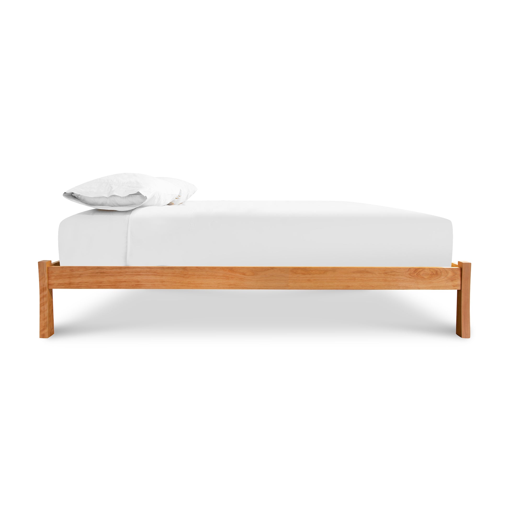 A minimalistic, sustainably sourced Contemporary Craftsman Studio-Style Platform Bed from Vermont Furniture Designs with a white mattress and a single pillow against a white background, featuring an eco-friendly oil finish.