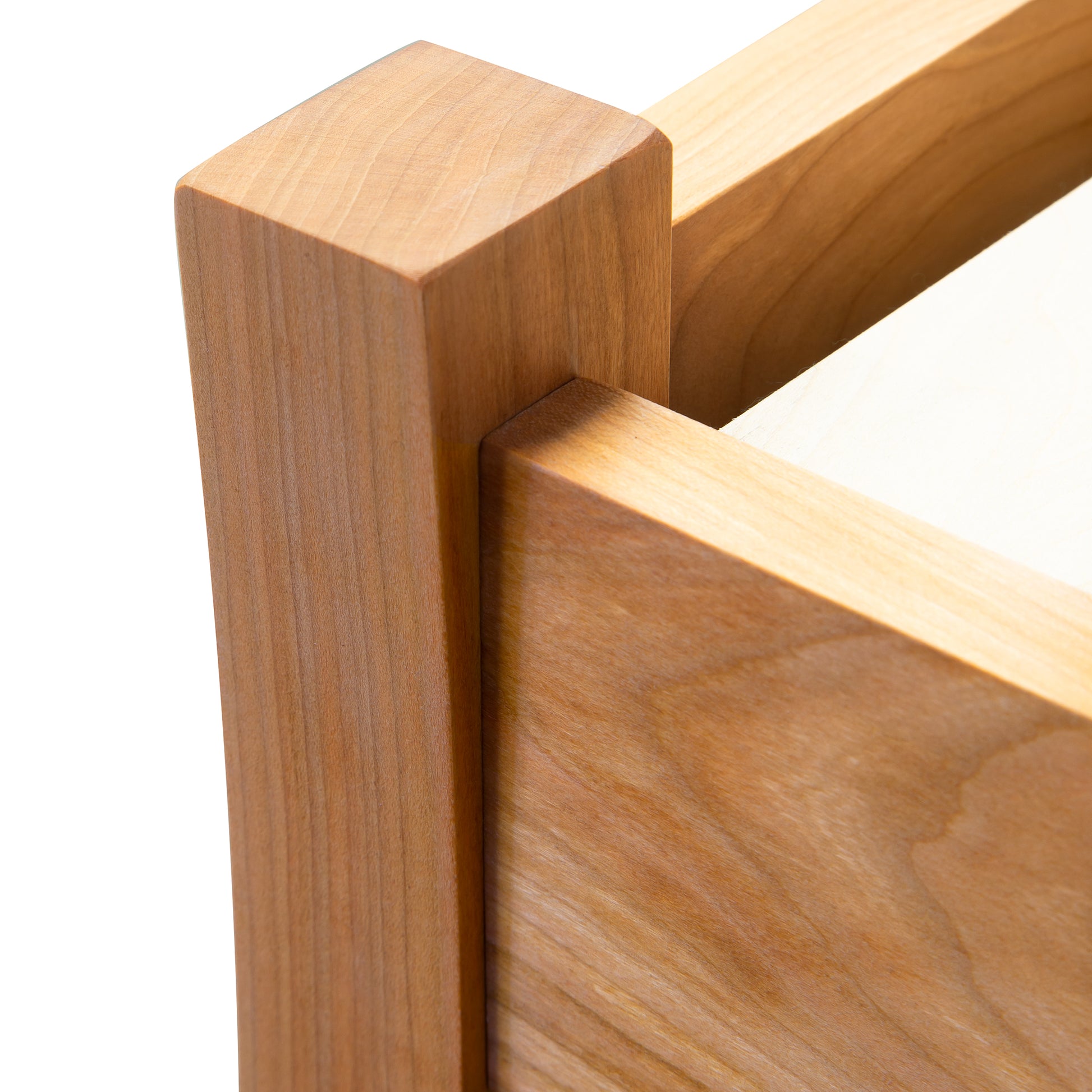 Close-up of a Contemporary Craftsman bed corner featuring smooth grain and angular joints, crafted from sustainably sourced hardwood by Vermont Furniture Designs.