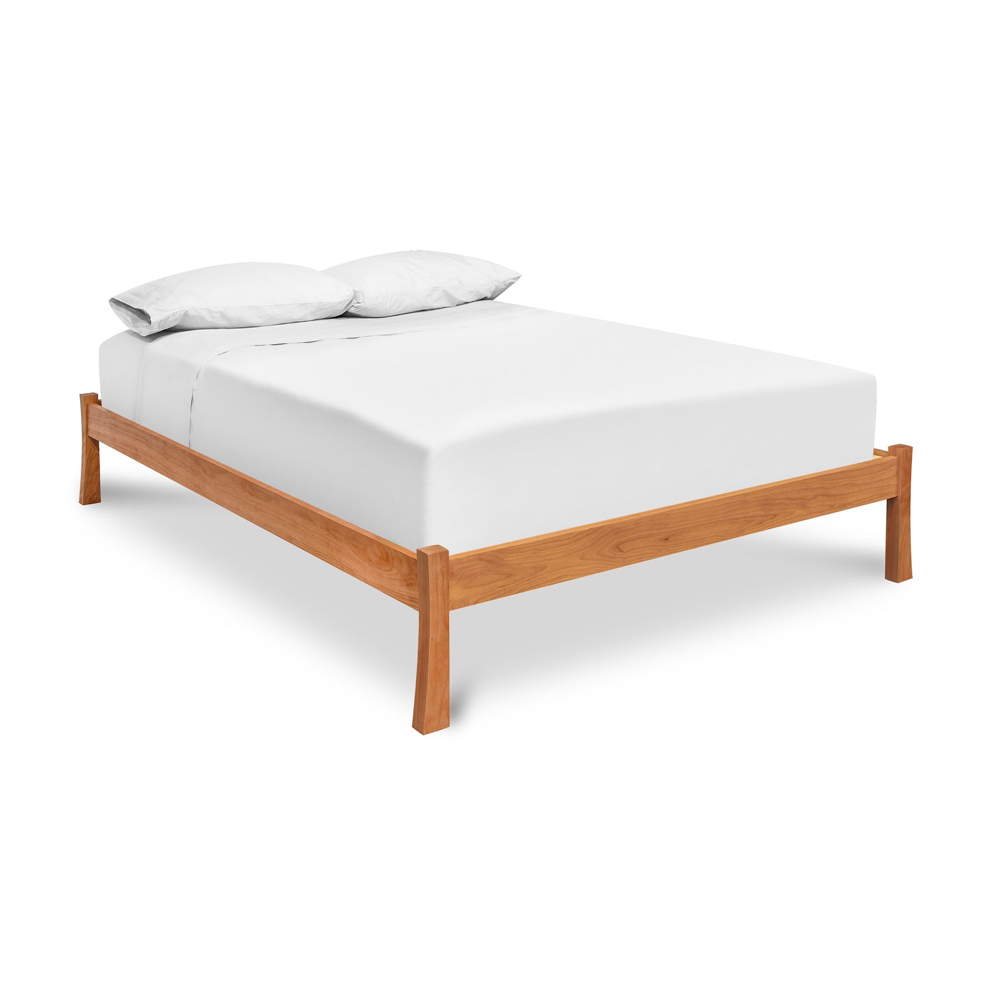 A simple Vermont Furniture Designs Contemporary Craftsman Studio-Style Platform Bed frame, crafted from sustainably sourced hardwood with an eco-friendly oil finish, complete with a white fitted sheet, white flat sheet, and two pillows.