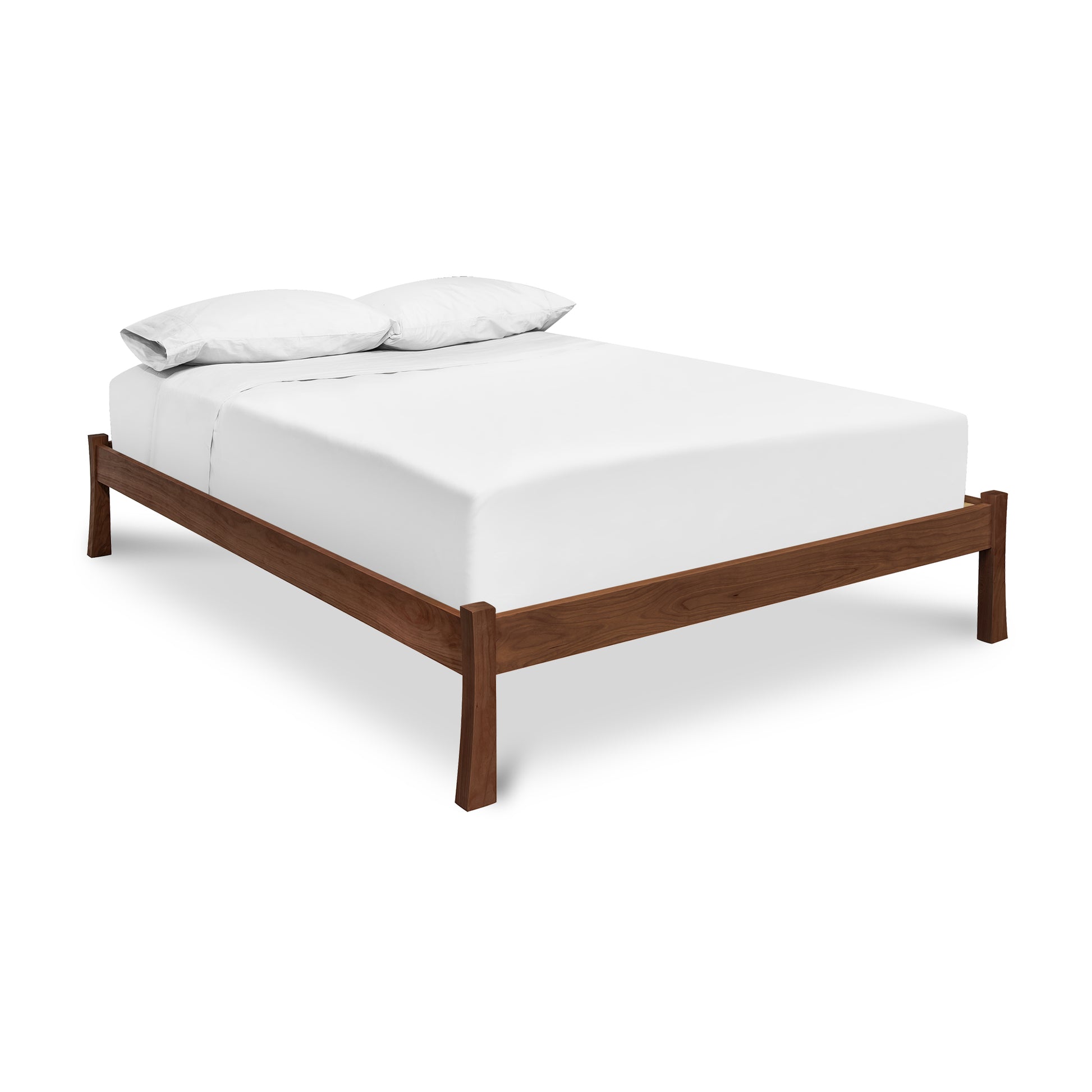 A sustainably sourced Contemporary Craftsman Studio-Style Platform Bed frame from Vermont Furniture Designs with a white mattress and two pillows against a white background.