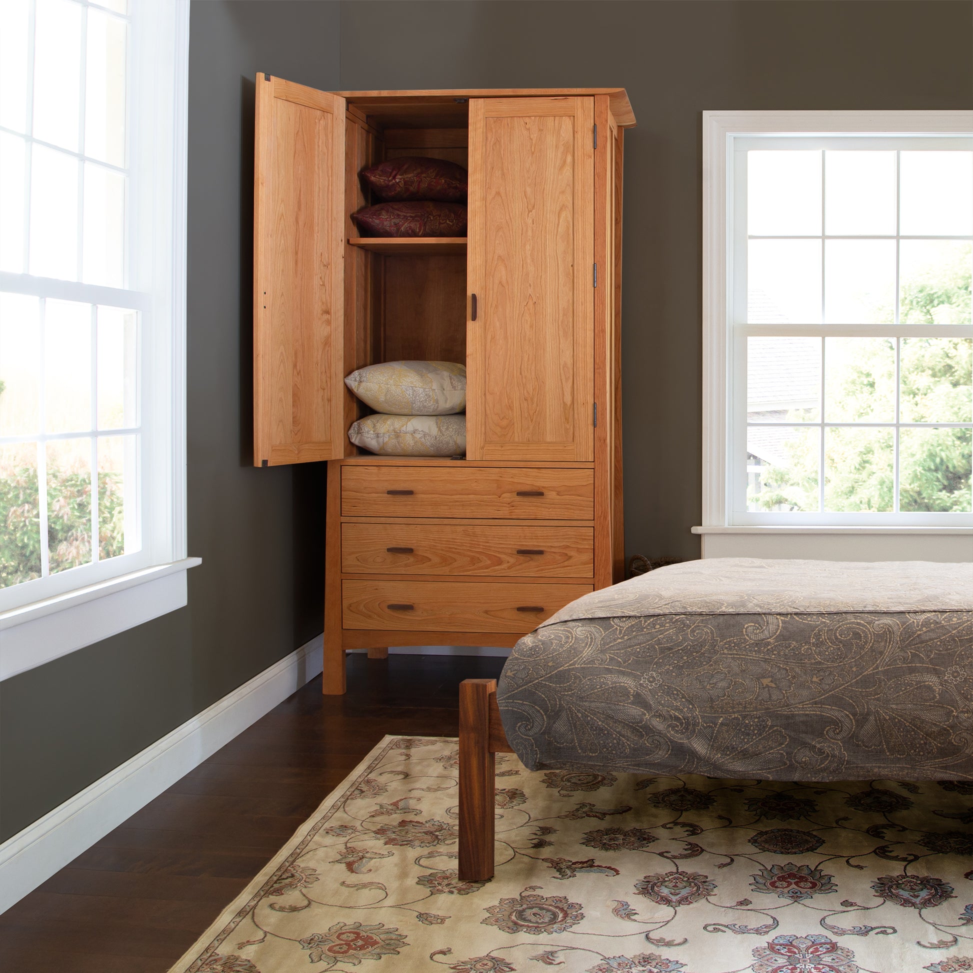 Vermont Furniture Designs Contemporary Craftsman Tall Armoire in natural wood, shown with doors open displaying folded blankets and pillows.