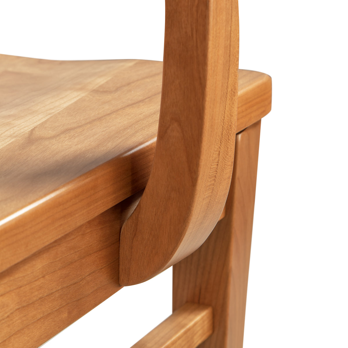 Close-up of Vermont Woods Studios’ discontinued Contemporary Shaker Chair highlighting its wood seat, backrest support, and leg.
