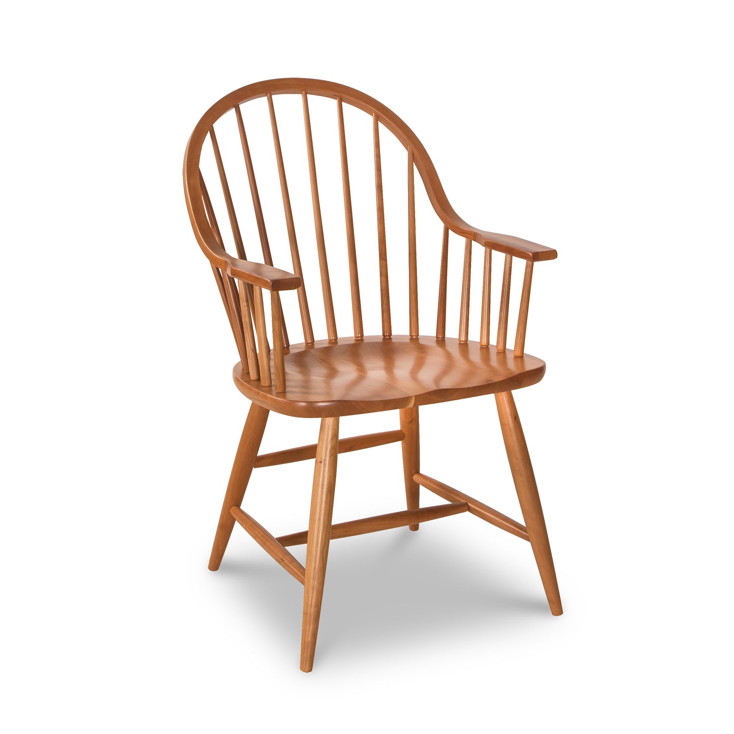 Contemporary Windsor Chair with cherry wood spindle backrest, curved armrests, and four tapered legs by Lyndon Furniture.