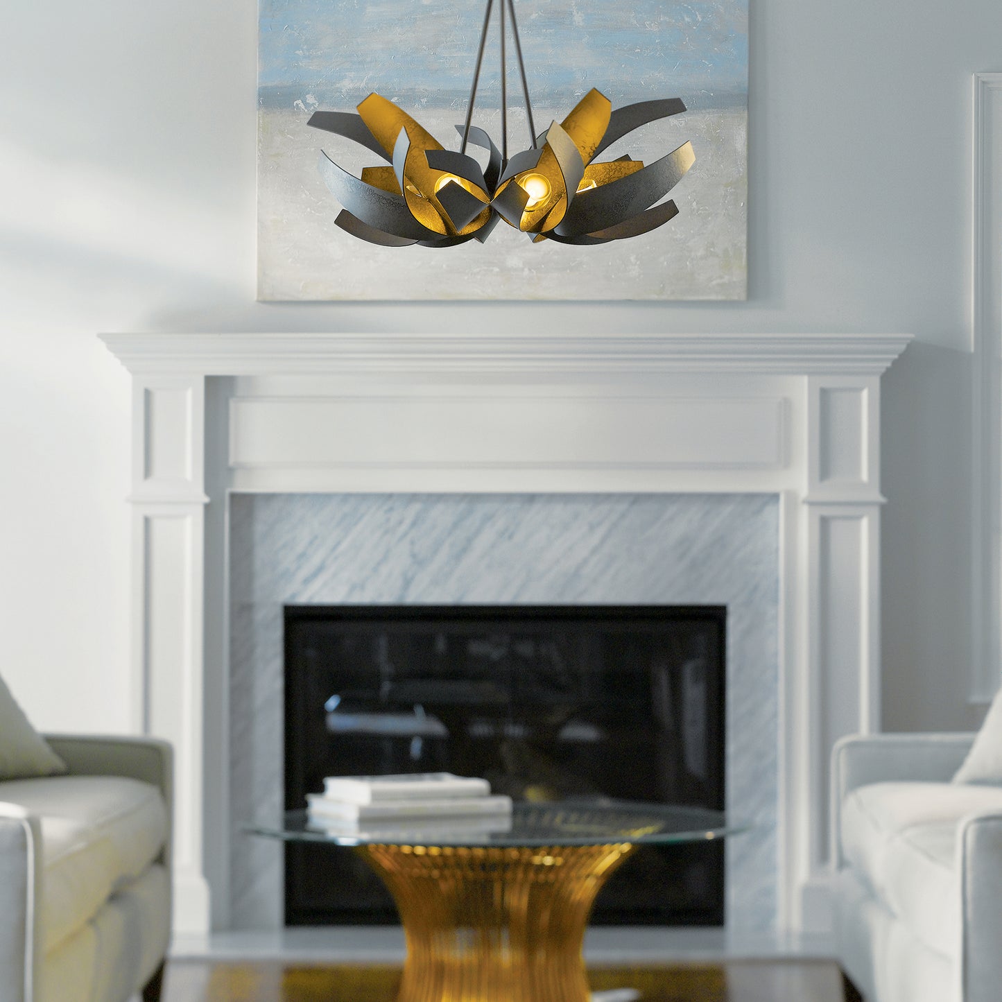 Two light sofas and a glass coffee table under a Hubbardton Forge Corona Pendant.