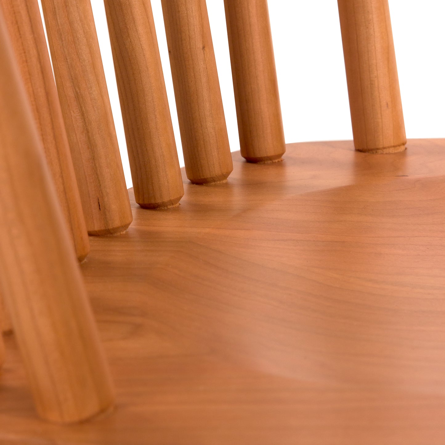 Lyndon Furniture Country Windsor Chair featuring a smooth natural cherry wood seat and classic vertical wooden spindle backrest.