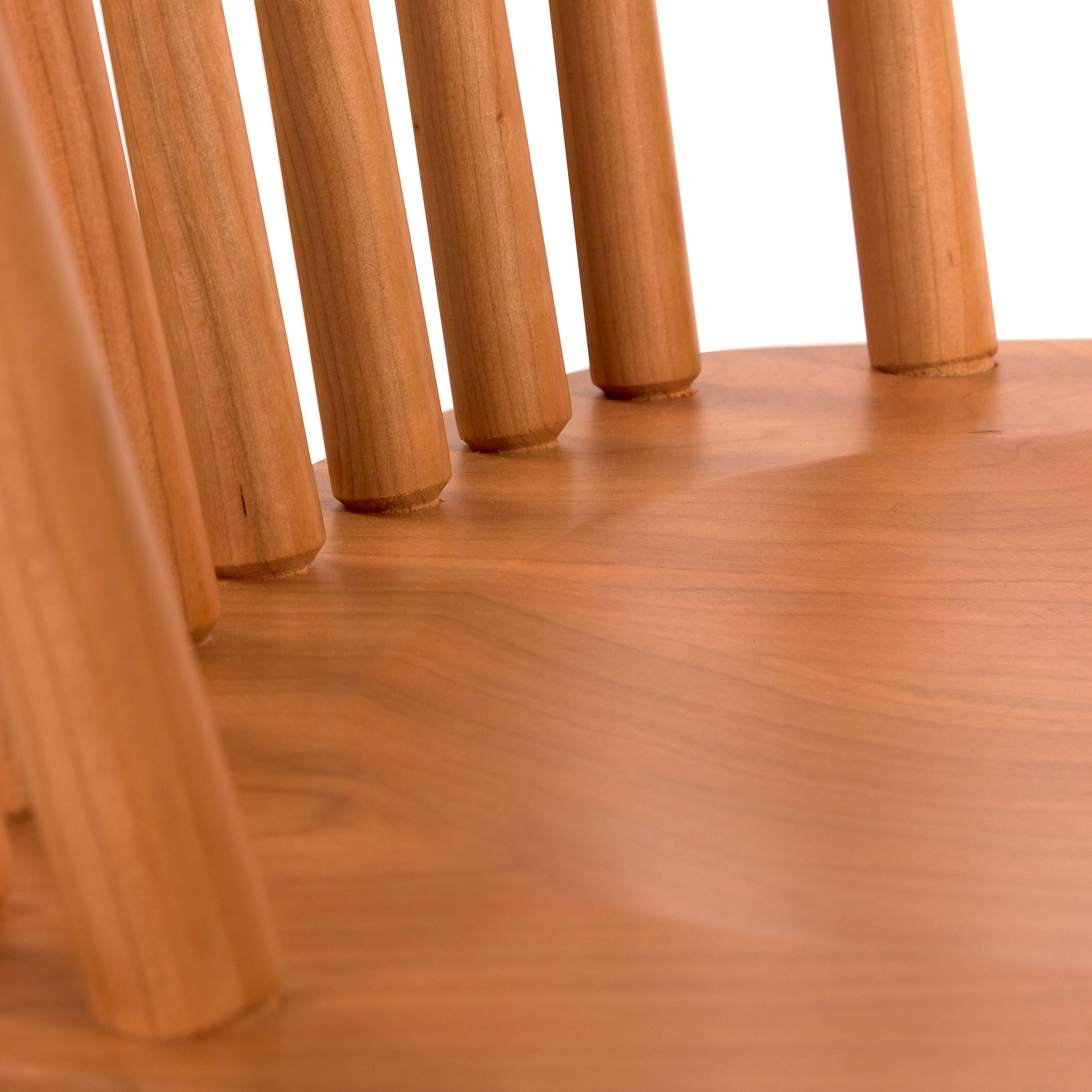 Lyndon Furniture Country Windsor Chair featuring a smooth natural cherry wood seat and classic vertical wooden spindle backrest.