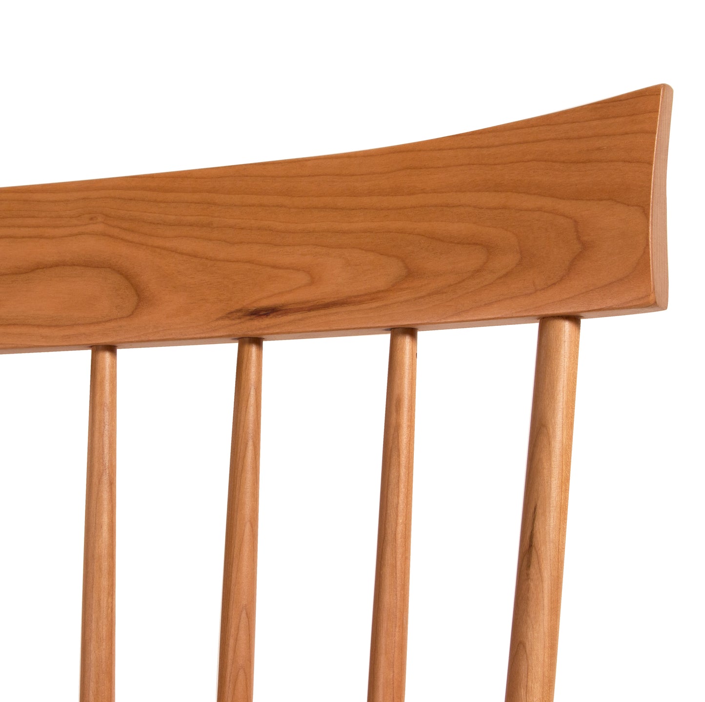 Detailed view of the Lyndon Furniture Country Windsor Chair's cherry wood backrest and spindles, showcasing craftsmanship and wood grain.