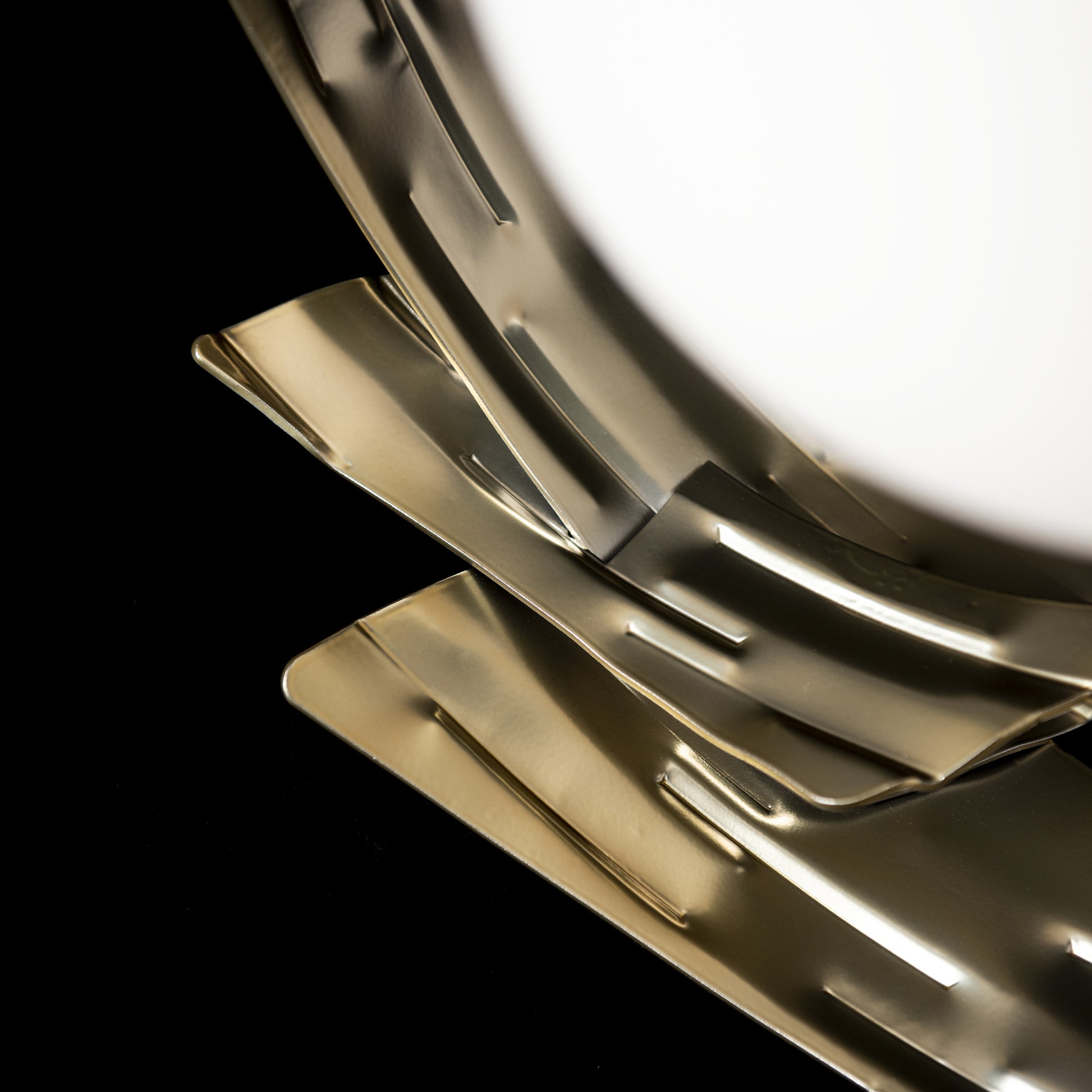 Crest Table Lamp by Hubbardton Forge with curved brass-like plates showcasing its elegant design.