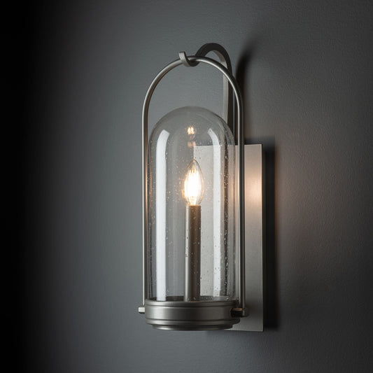 Davis Small Outdoor Sconce featuring a hand-forged steel base, clear glass dome, and single bulb, handcrafted by Hubbardton Forge.