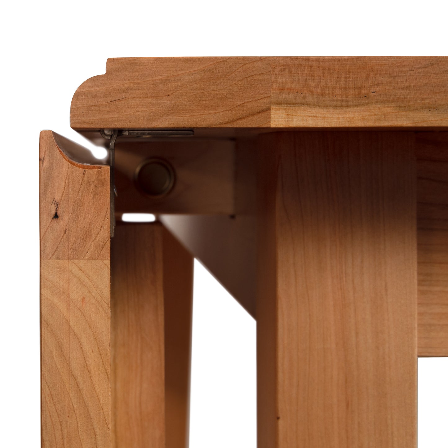 Lyndon Furniture Drop Leaf Table in cherry wood, highlighting the detailed leg design with metal hinge and folding mechanism.