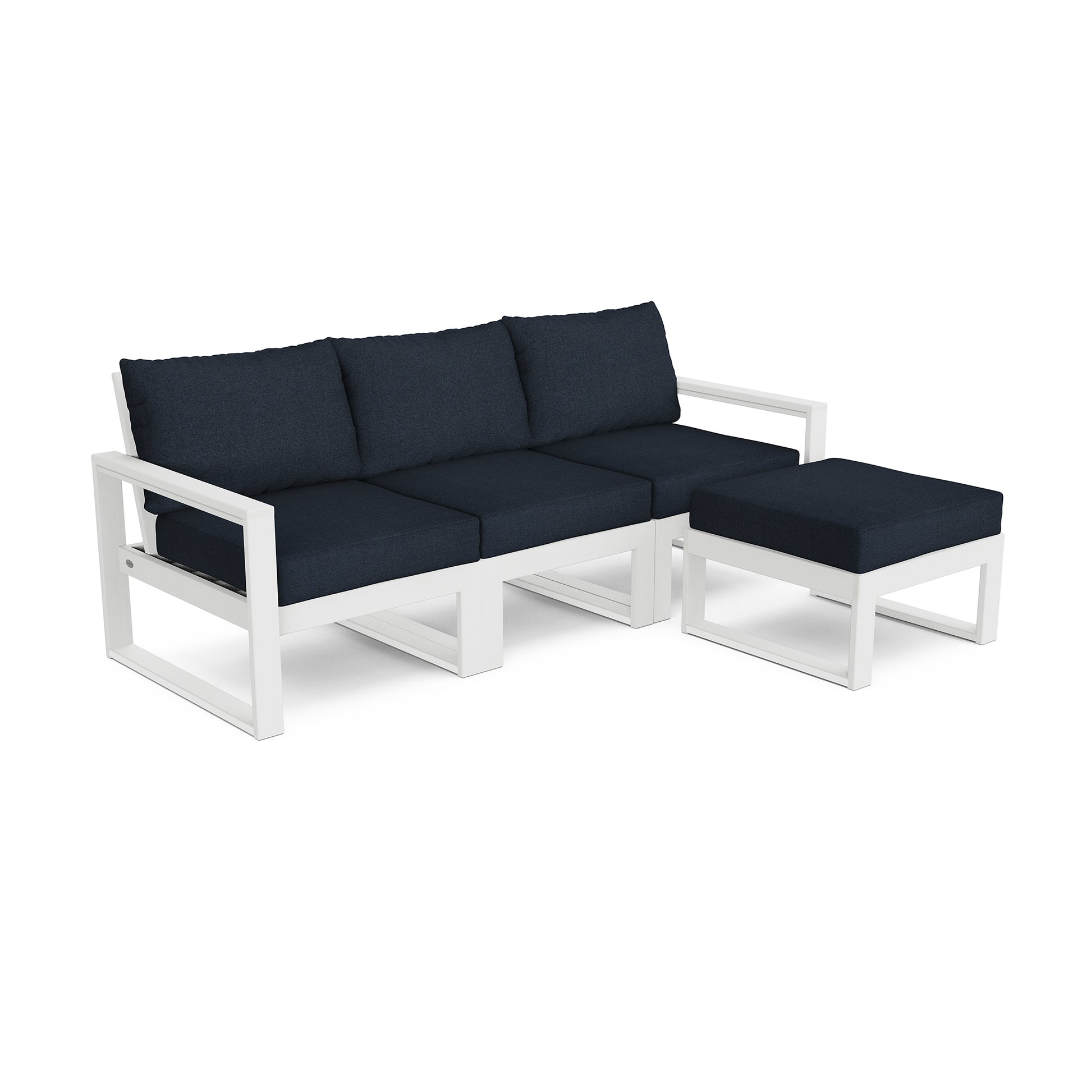 A modern POLYWOOD EDGE 4-Piece Modular Deep Seating Set with Ottoman featuring a white frame with deep blue cushions. This set includes a three-seat sofa and a matching ottoman, all on a clean white background.