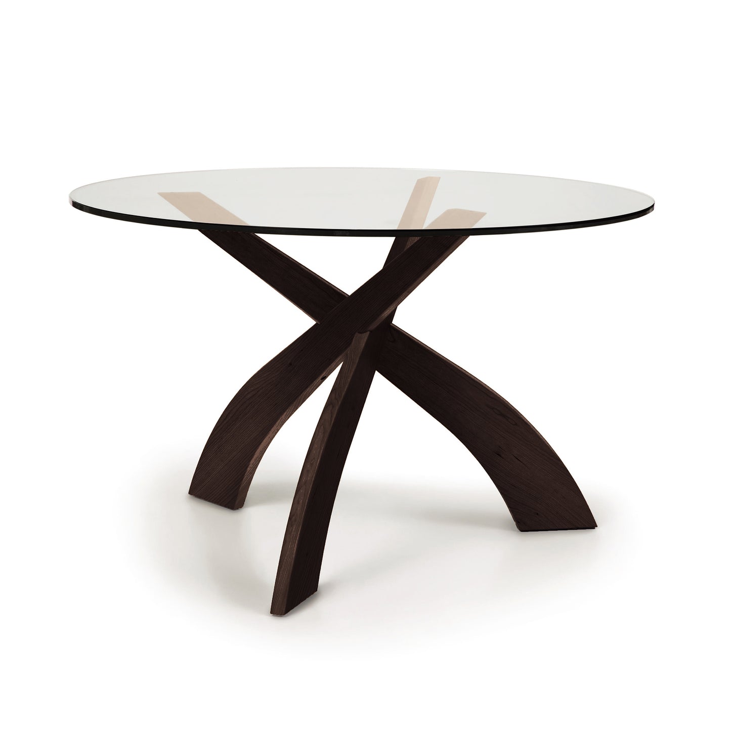 Copeland Entwine round dining table with clear glass top and three sculpted cherry wood legs.