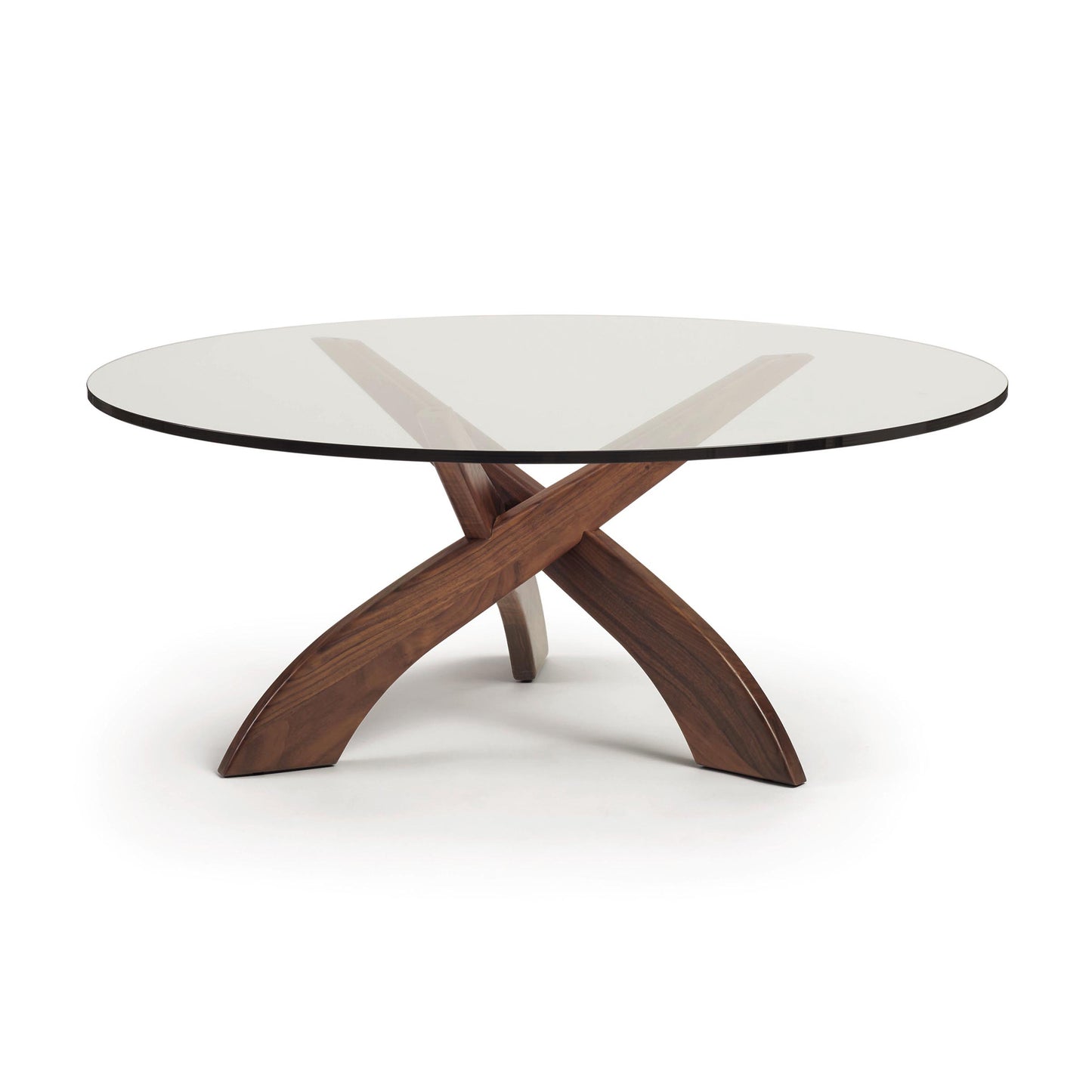 A high-end Entwine Walnut Round Coffee Table - Ready to Ship by Copeland Furniture with a glass top and wooden legs.