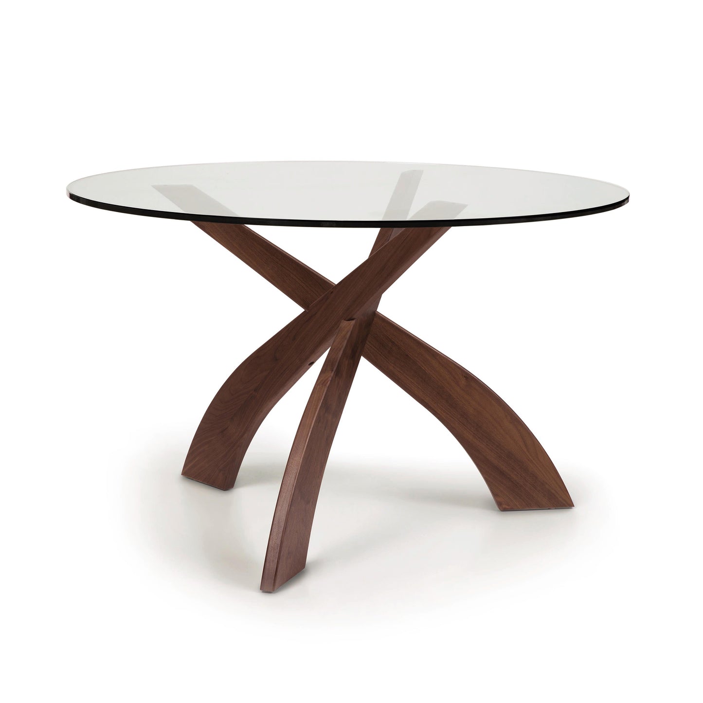 Entwine Round Glass Top Dining Table by Copeland Furniture with sculptural intersecting cherry wood legs and a circular glass surface.