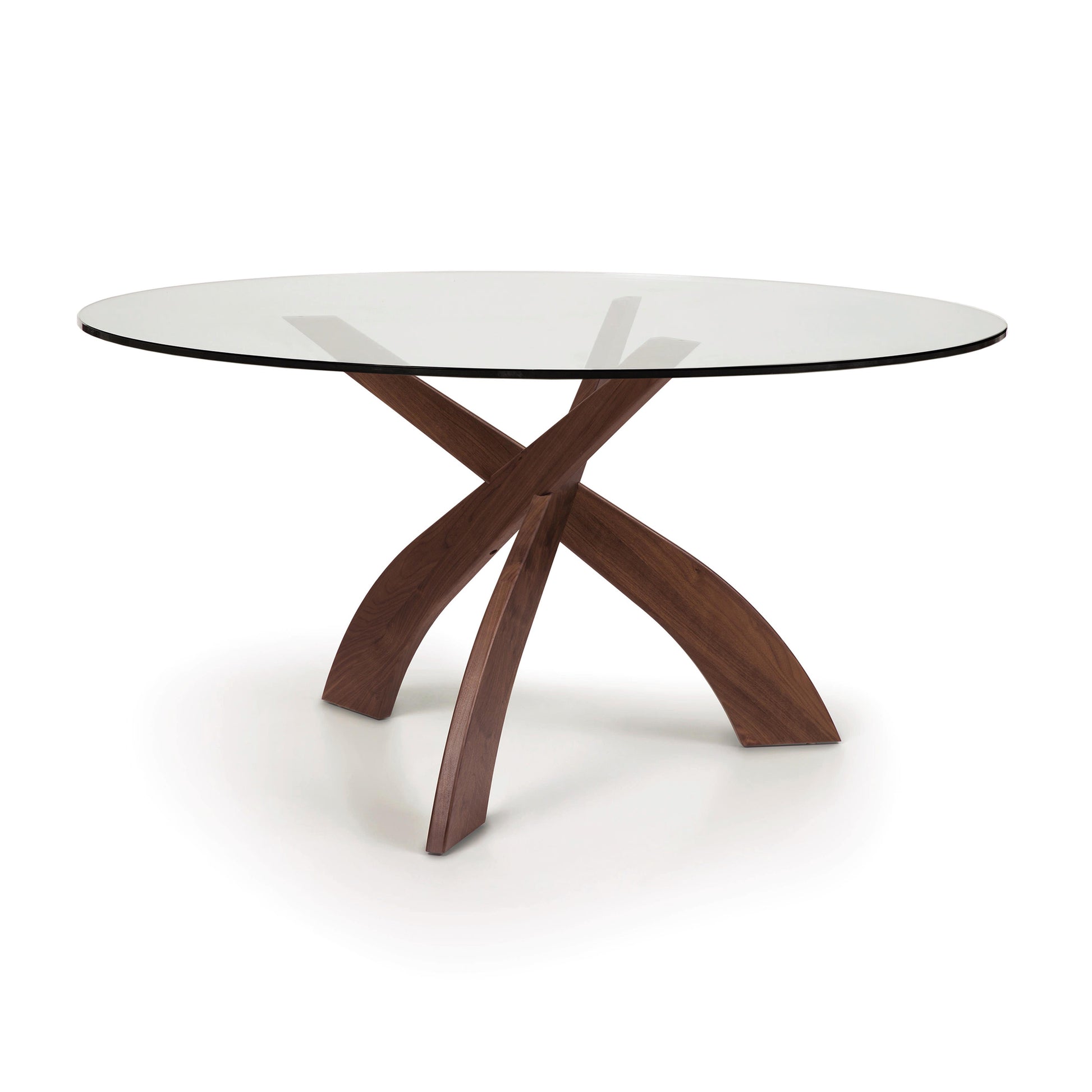 Round glass top dining table by Copeland featuring artistic curved walnut legs from the Statement Collection.