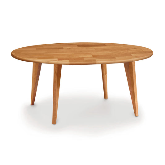 A Copeland Furniture Essentials Cherry Round Coffee Table with Wood Legs, isolated on a white background.