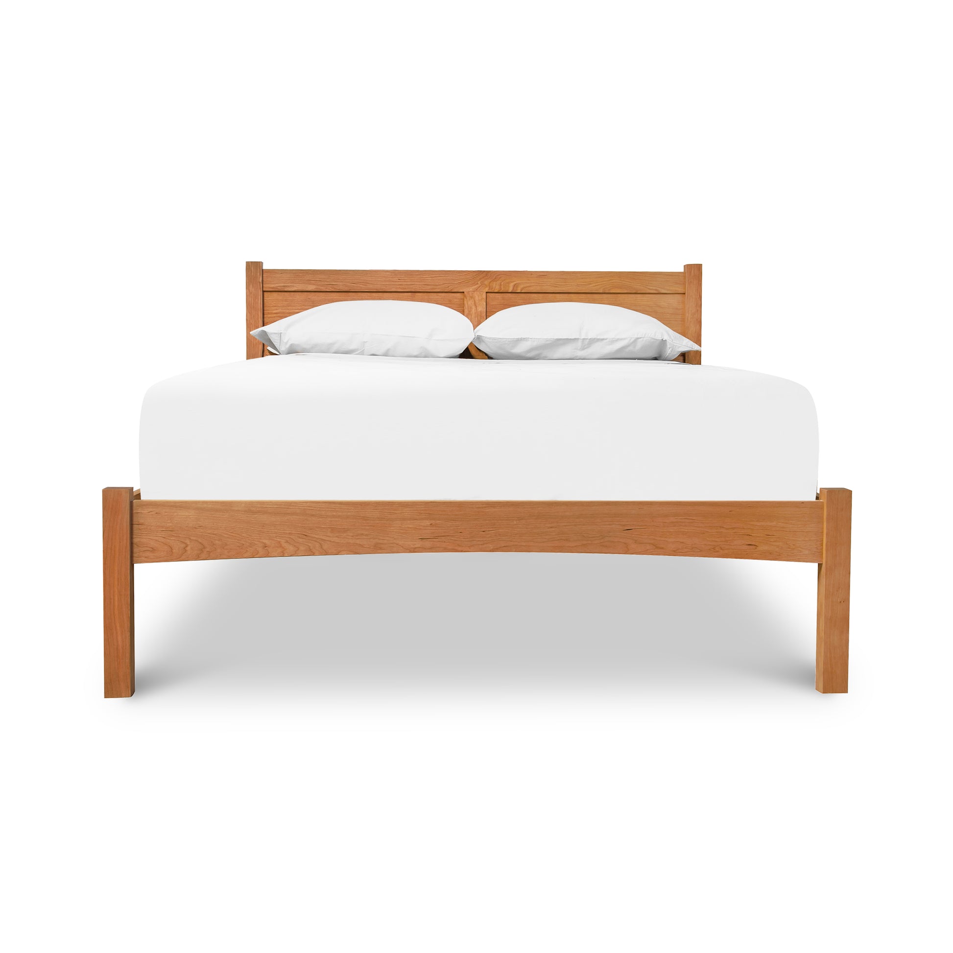 A cherry wood Vermont Furniture Designs Essex Low Footboard Bed with white bedding isolated on a white background.
