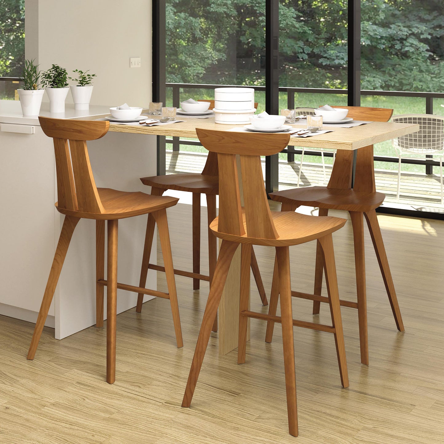 Set of four Estelle Counter Stools by Copeland Furniture, handcrafted from solid hardwood, displayed around a kitchen island.