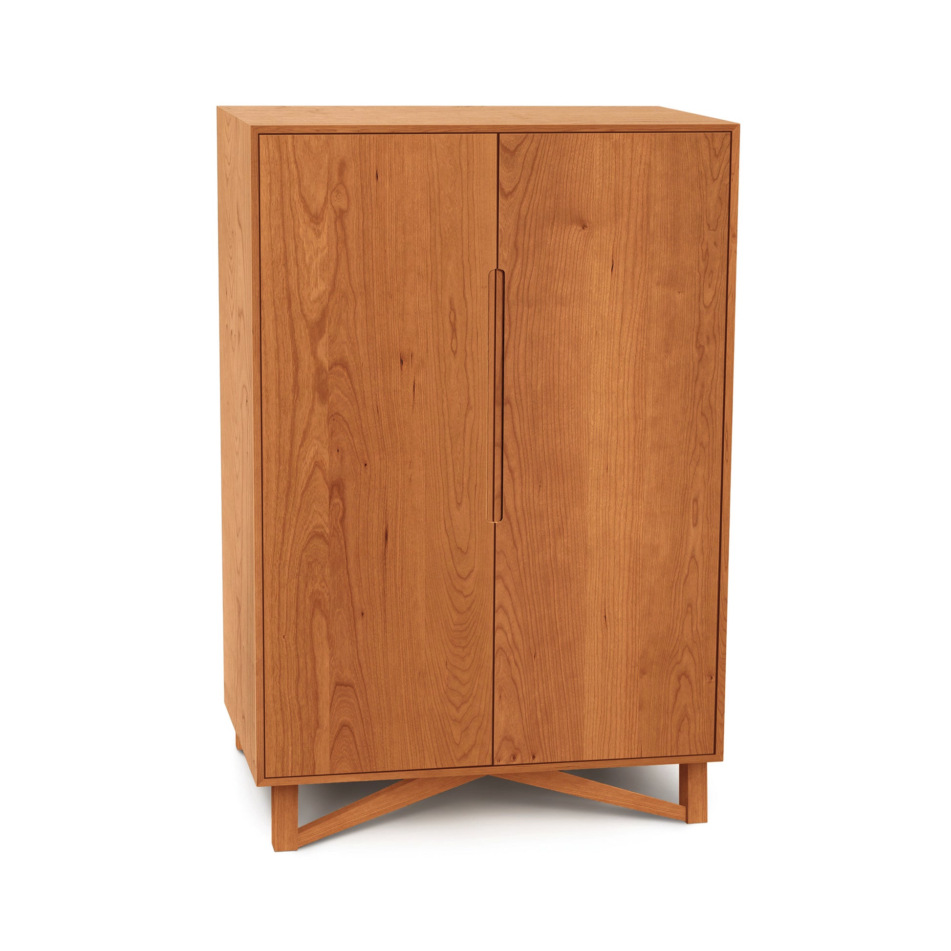 Medium Exeter Bar Cabinet by Copeland Furniture with two doors, elegant handles, and a distinctive crisscross base in mid-century modern design.