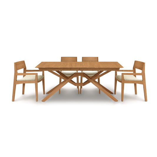 An Exeter Extension Dining Table set by Copeland Furniture with six matching chairs and a butterfly leaf extension on a white background.