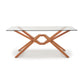 A modern Copeland Furniture Exeter Rectangular Glass Top Table with a solid wood x-shaped base on a white background.