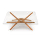 A modern Copeland Furniture Exeter Rectangular Glass Top Table with a glass top and a wooden star-shaped base, made-to-order.