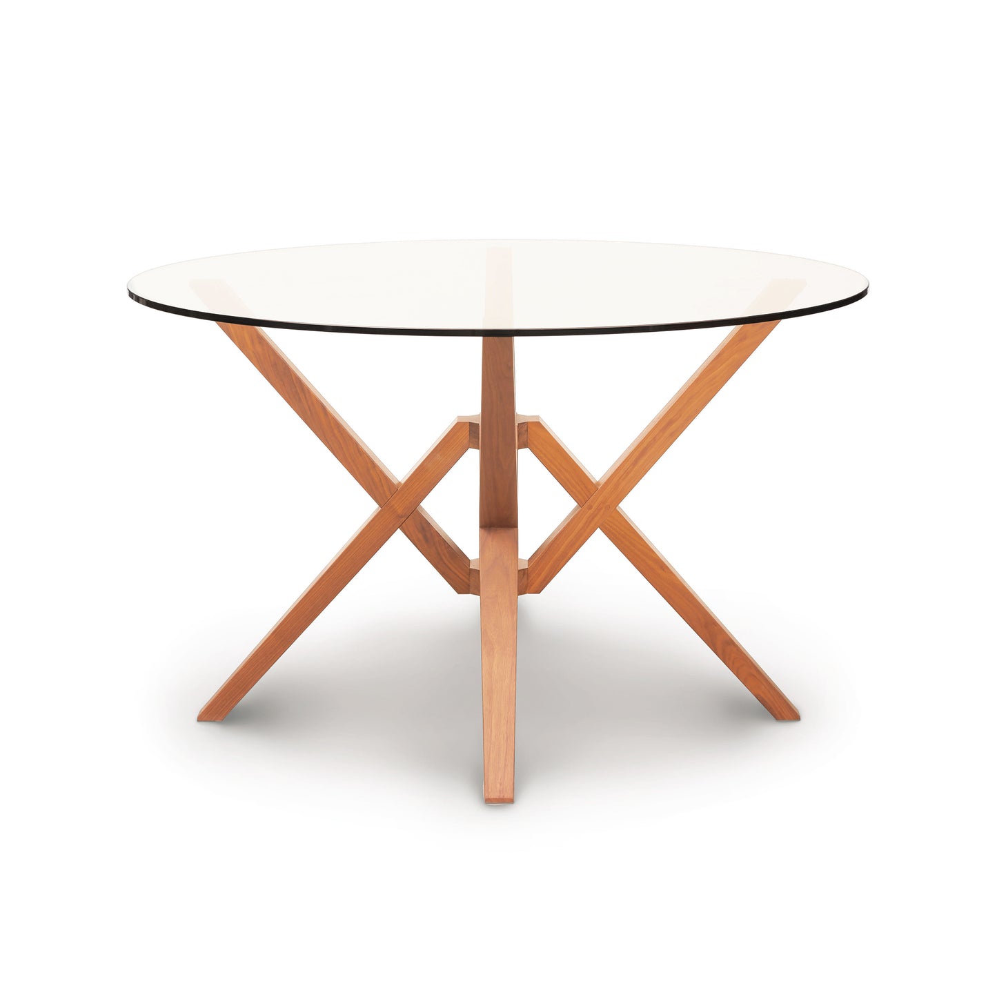 Copeland Furniture Exeter Round Glass Top Table with a solid wood crossed-leg base on a white background.
