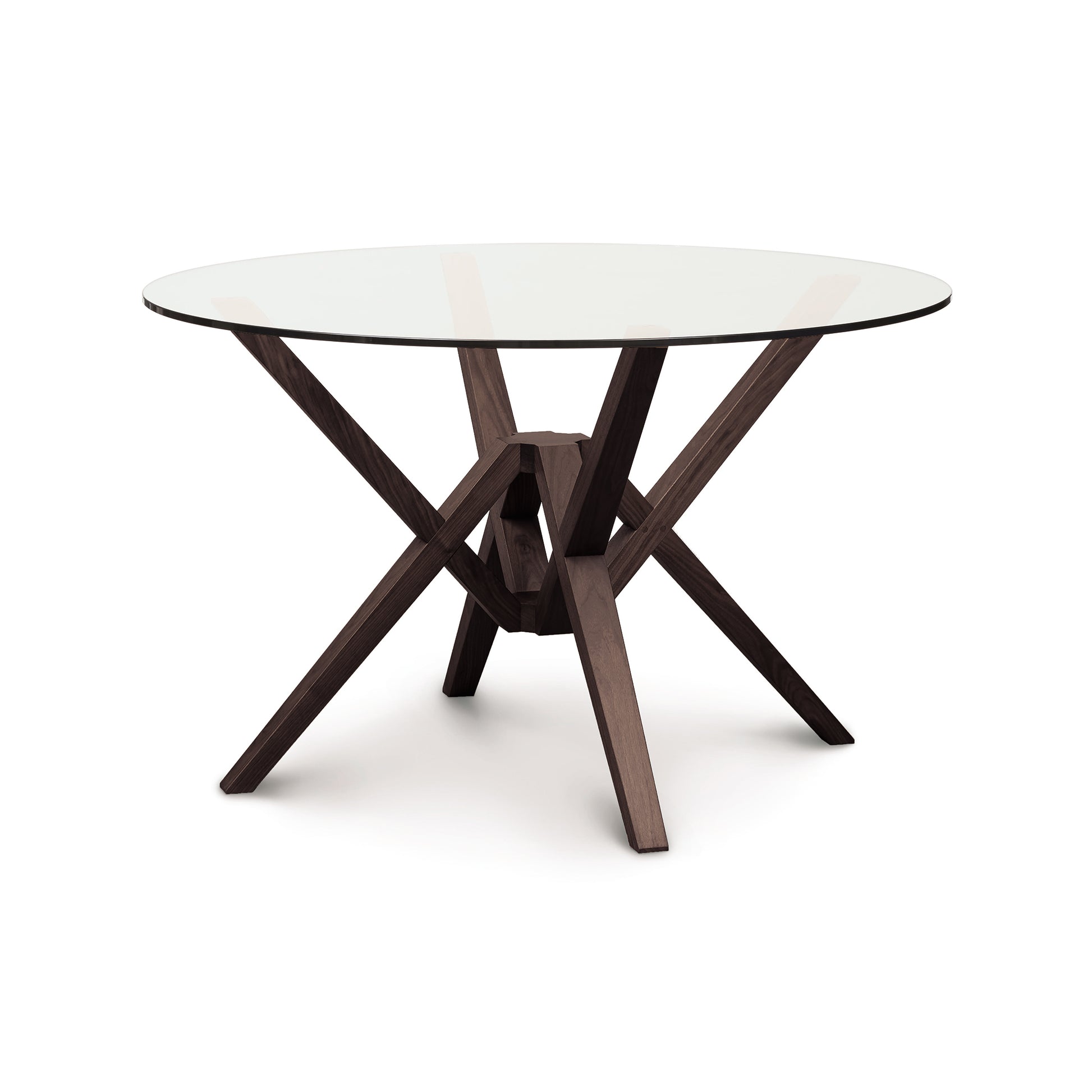 Exeter Round Glass Top Table by Copeland Furniture with a sculptural geometric hardwood base and contemporary glass surface, showcasing modern craftsmanship.