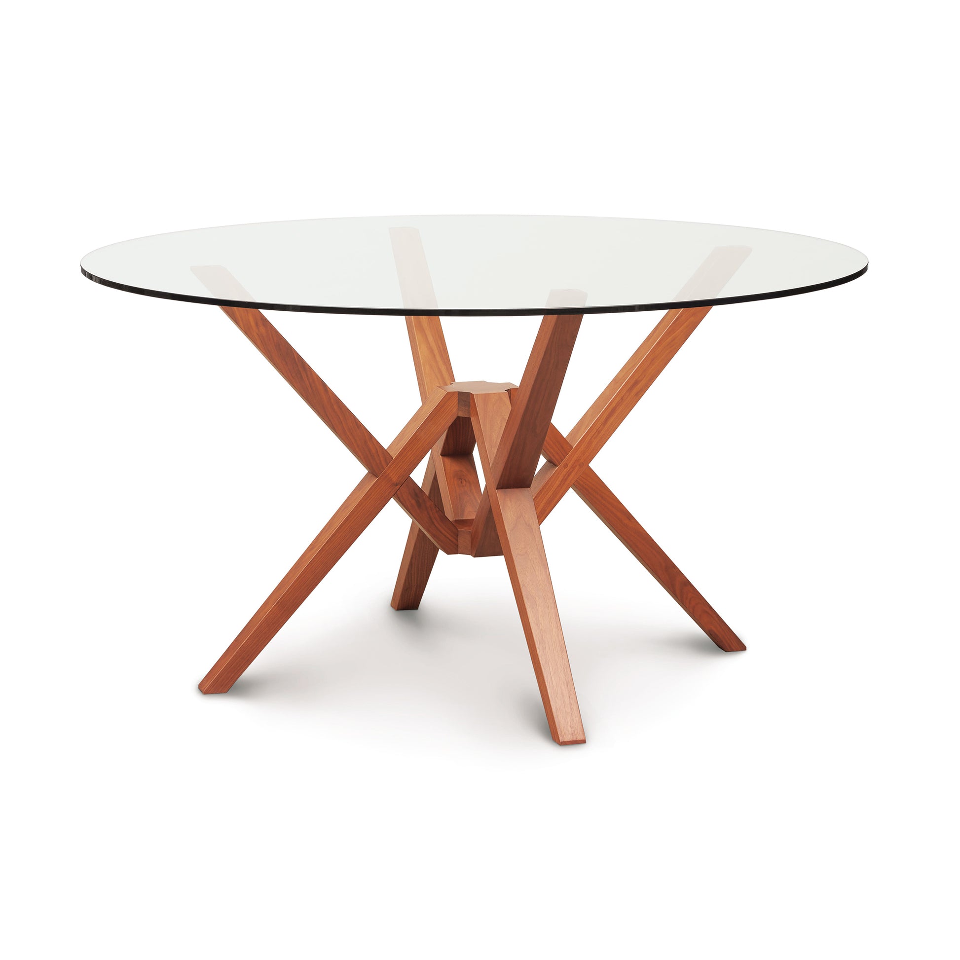 Copeland Furniture Exeter round glass top table featuring a striking geometric hardwood base, highlighted against a plain white background.