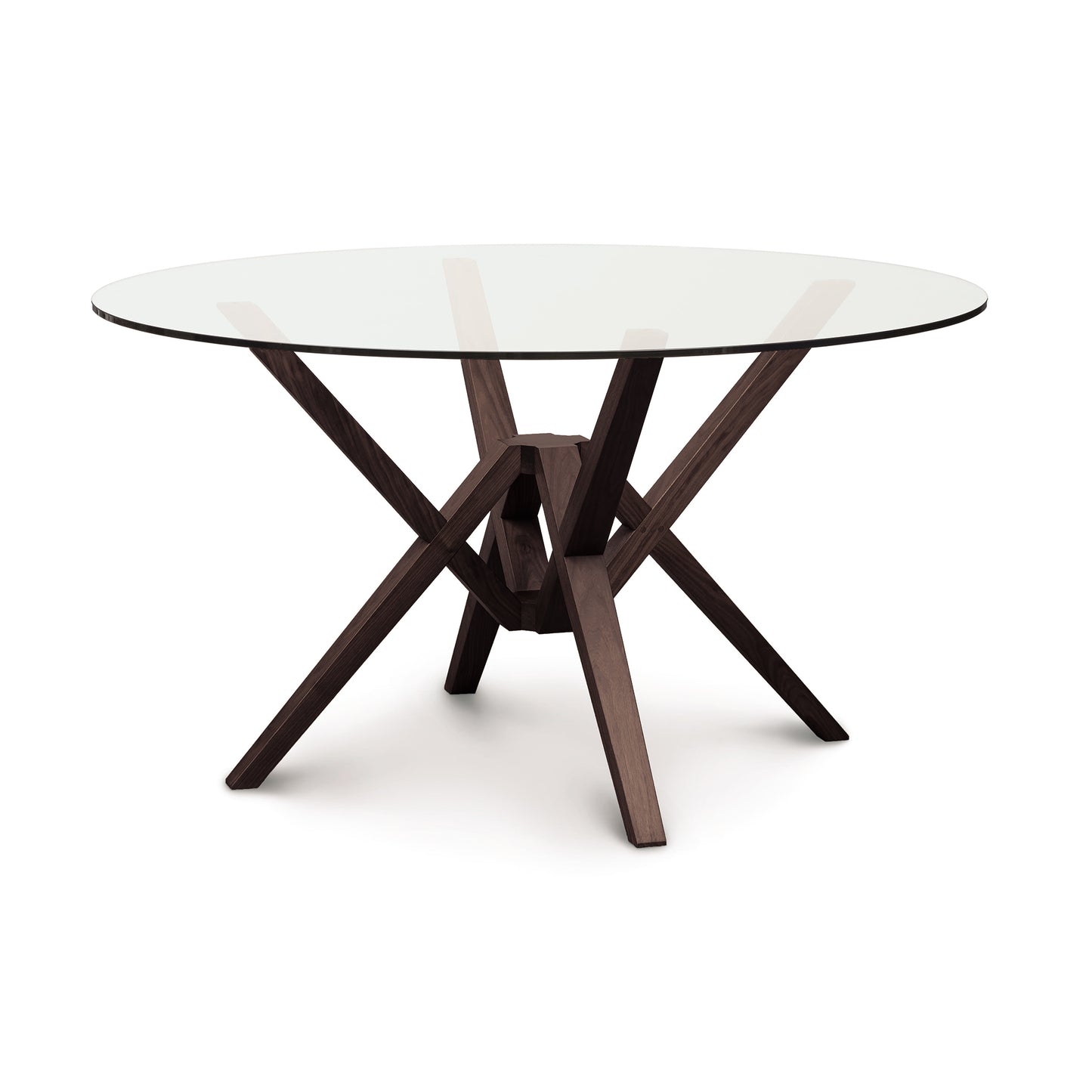 Exeter round glass top dining table by Copeland Furniture featuring a sculpted solid wood base, highlighting its modern craftsmanship.