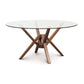 Copeland Furniture's Exeter Round Glass Top Dining Table with a solid wood cross base design is showcased on a white background.