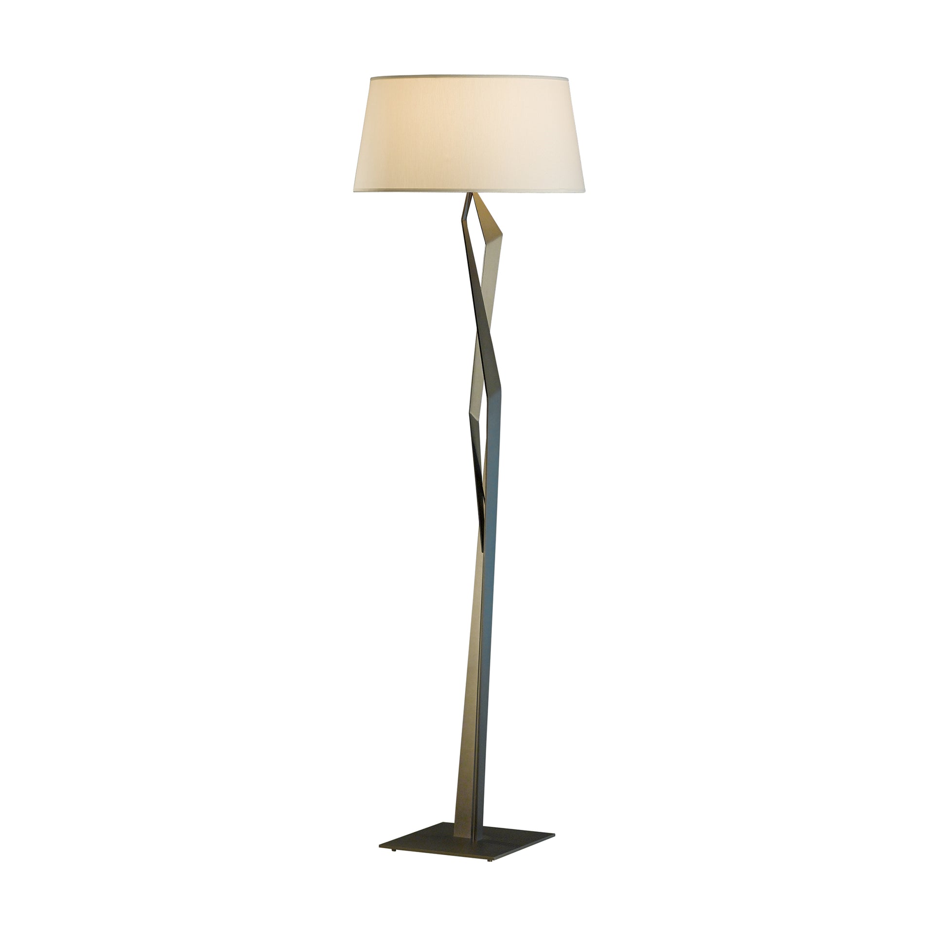 A modern Hubbardton Forge Facet Floor Lamp with a twisted metal base and a large, round beige lampshade, isolated on a white background.