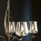 A hand-crafted chandelier with three glass candle holders, the Flora 5-Arm Chandelier by Hubbardton Forge embodies the rustic charm of Vermont.